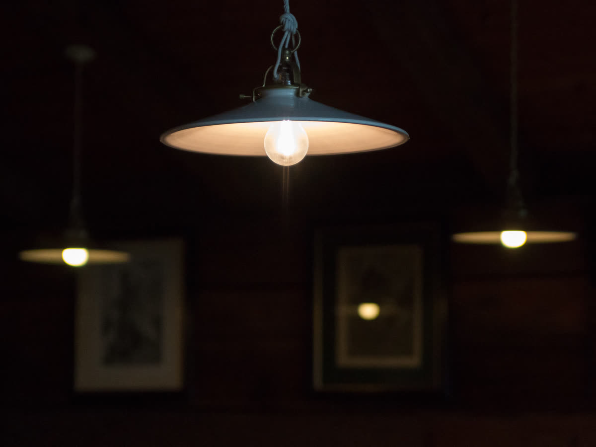 Suspensions allumées au-dessus d'une table, ambiance chaleureuse du soir